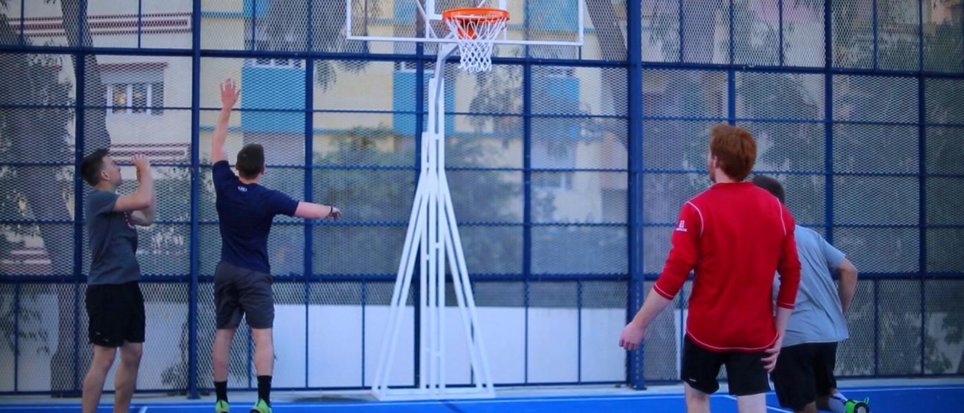 Students play basketball on the basketball and volleyball court at U N E Tangier